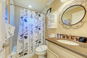 Un baño con cortina de ducha, inodoro, lavabo y espejo.
