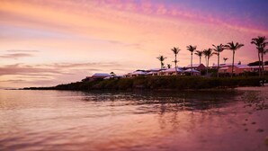 A beachfront property with multiple villas, palm trees, and a calm sea at sunset. - Shared Pools & Private Beaches! Room w/Garden View (Sandys Parish)