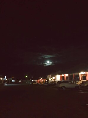 A nighttime street scene with buildings and parked cars. - Hostería Cotopaxi Tour (Tanicuchi)