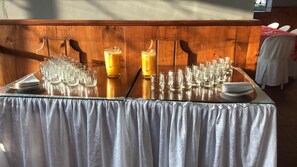 A table set with multiple glasses and a large pitcher, likely for a beverage service. - Hostería Cotopaxi Tour (Tanicuchi)