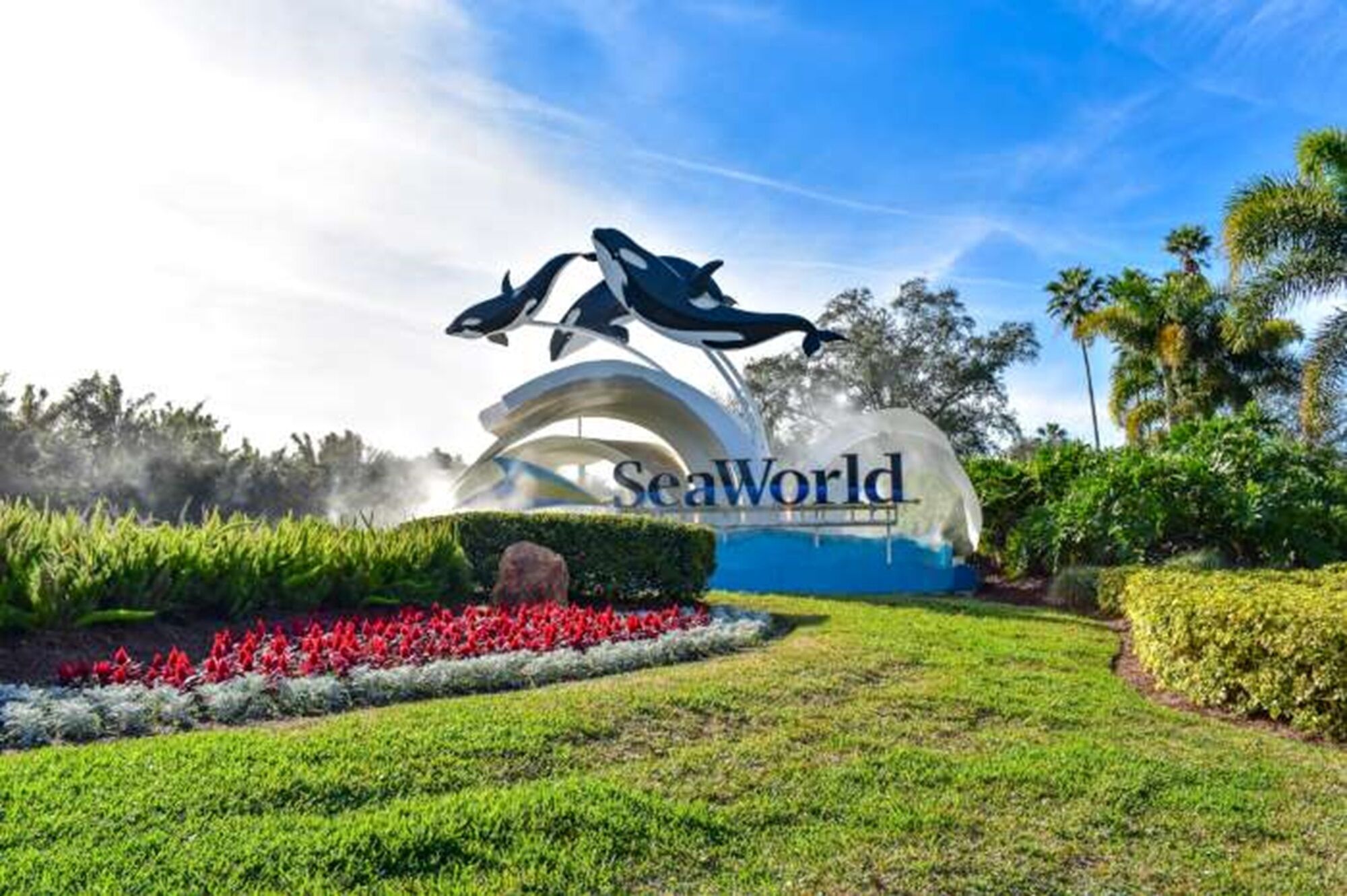 A large sculpture of dolphins above a sign that reads "SeaWorld."