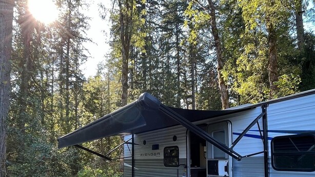 A recreational vehicle with an attached awning, a fire pit, and outdoor seating. - Quiet, majestic views of the Shire in a cozy glamping set up!  (Brush Prairie)