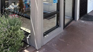 A storefront with a glass door, ATMs, and a wheelchair-accessible entrance. - Stay Inn Motel (Harbor City)