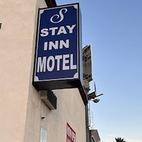 Un letrero para un motel que dice 'STAY INN MOTEL'.