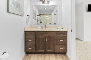 Een bad/douchecombinatie, een haardroger, handdoeken