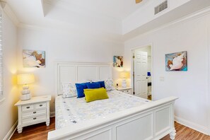 A bedroom with a bed, nightstands, and wall art. - Elevated Condo With Wraparound Porch at Reunion (Kissimmee)