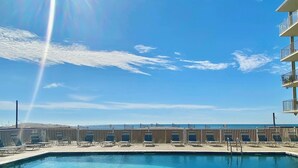 Une piscine avec des chaises longues et vue sur l’océan.