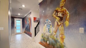 A hallway with a mural of a golden robot and a blue and white droid. - 5BR/5BA Game/Pool Villa 9 Miles to Disney (Kissimmee)
