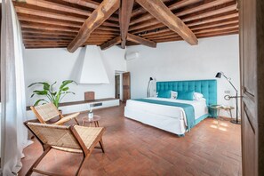 A bedroom with a large bed, a wooden ceiling, and a view of the outdoors. - Florence Apartments - Villa Fonte Morgana with Pool (Impruneta)