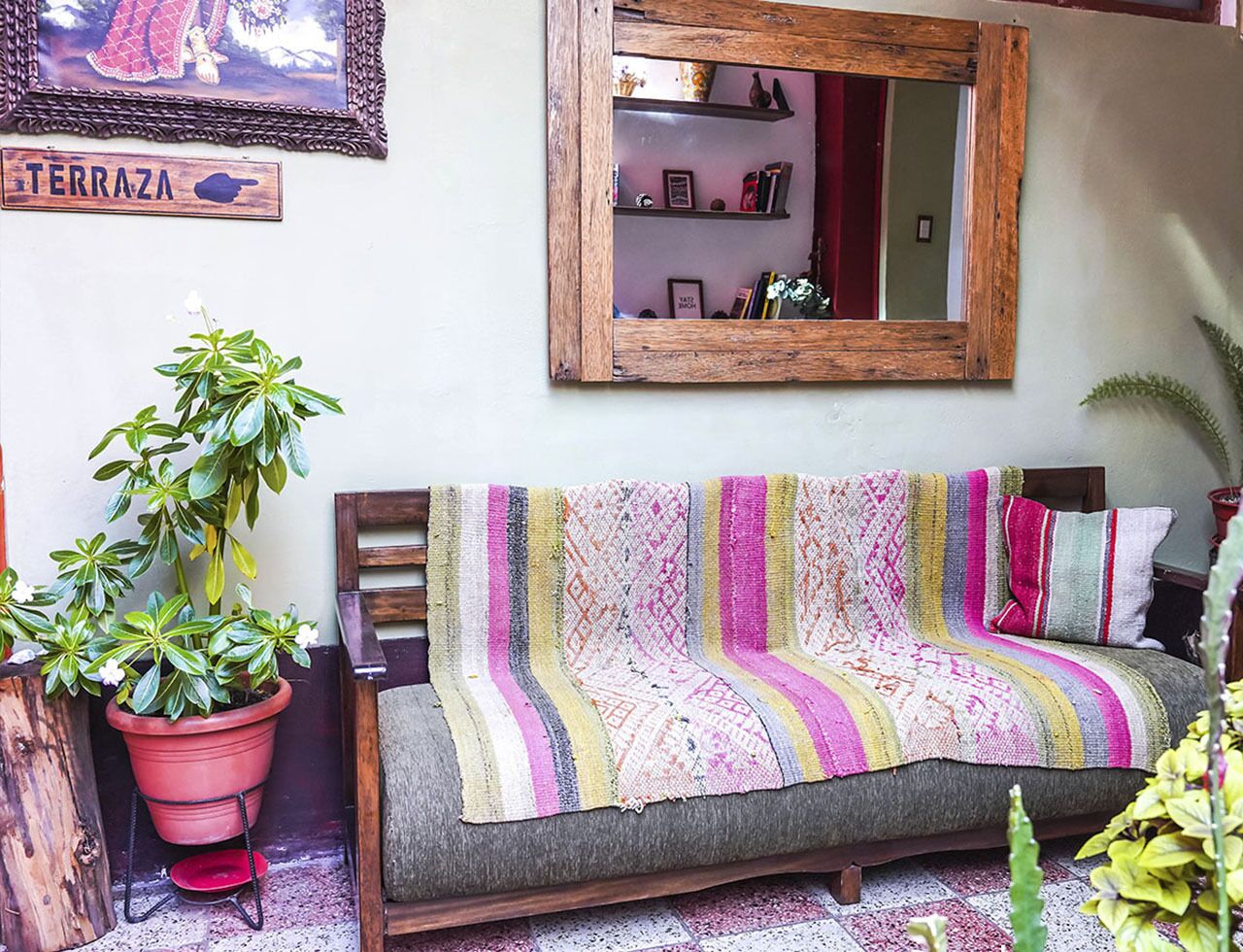 Un salón acogedor con un sofá, un espejo grande y una planta en maceta.