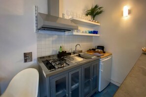 A compact kitchen with a gas stove, sink, dishwasher, and a small countertop.