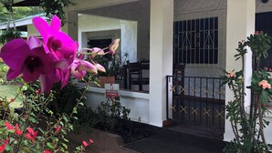 Une maison avec un porche couvert, une entrée fermée par un portail et un panneau indiquant « Stationnement interdit ».