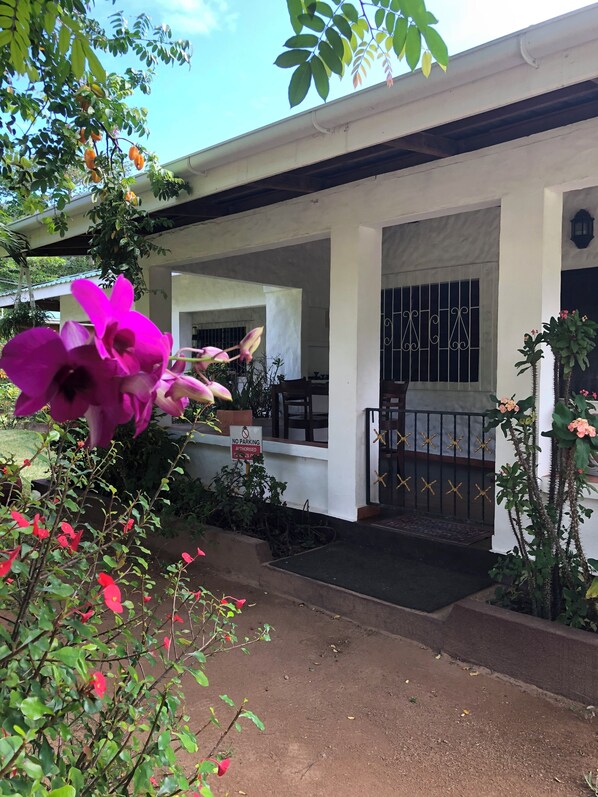 A house with a covered porch, a gated entrance, and a "No Parking" sign.