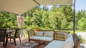 An outdoor patio with a wooden sofa, chairs, and a table. - Apartment "Balzerberg" with Garden & Wi-Fi (Weiler-Simmerberg)