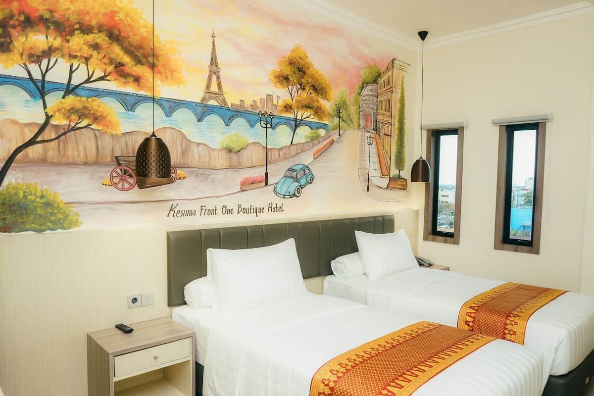 A hotel room with two beds, a mural of Paris, and a view of the city.