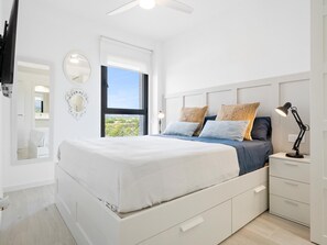Relax in a serene space with a large bed and a view of lush greenery.