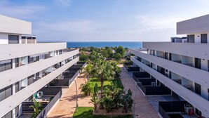 Ein modernes Hotel mit mehreren Etagen, Terrassen und Meerblick.