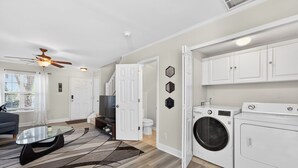 Un appartement moderne comprenant un salon, une cuisine et un espace buanderie.
