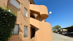 A building with a unique architectural design, featuring a curved facade and a small balcony.