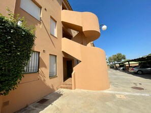 A building with a unique architectural design, featuring a curved facade and a small balcony.