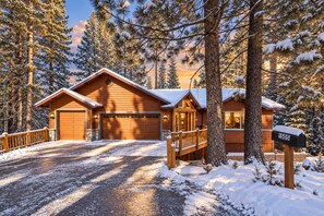 Une cabane avec un garage, une véranda et une boîte aux lettres.
