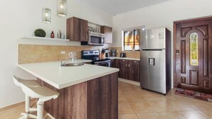Una cocina moderna con una isla central, electrodomésticos de acero inoxidable y armarios de madera.