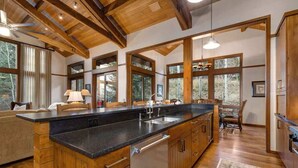 Une cuisine spacieuse avec des meubles en bois, un grand îlot central et une vue sur l’extérieur.