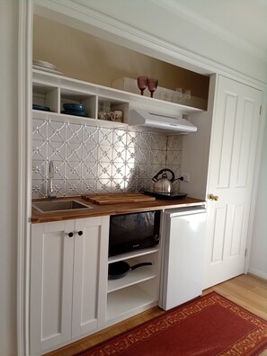 Kitchen includes induction cooktop, microwave oven, fridge ...