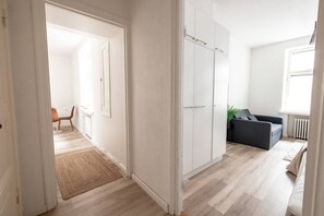 A modern apartment with a wooden floor, a grey sofa, and a white wardrobe. - 2ndhomes Cozy Studio in the Center (Helsinki)