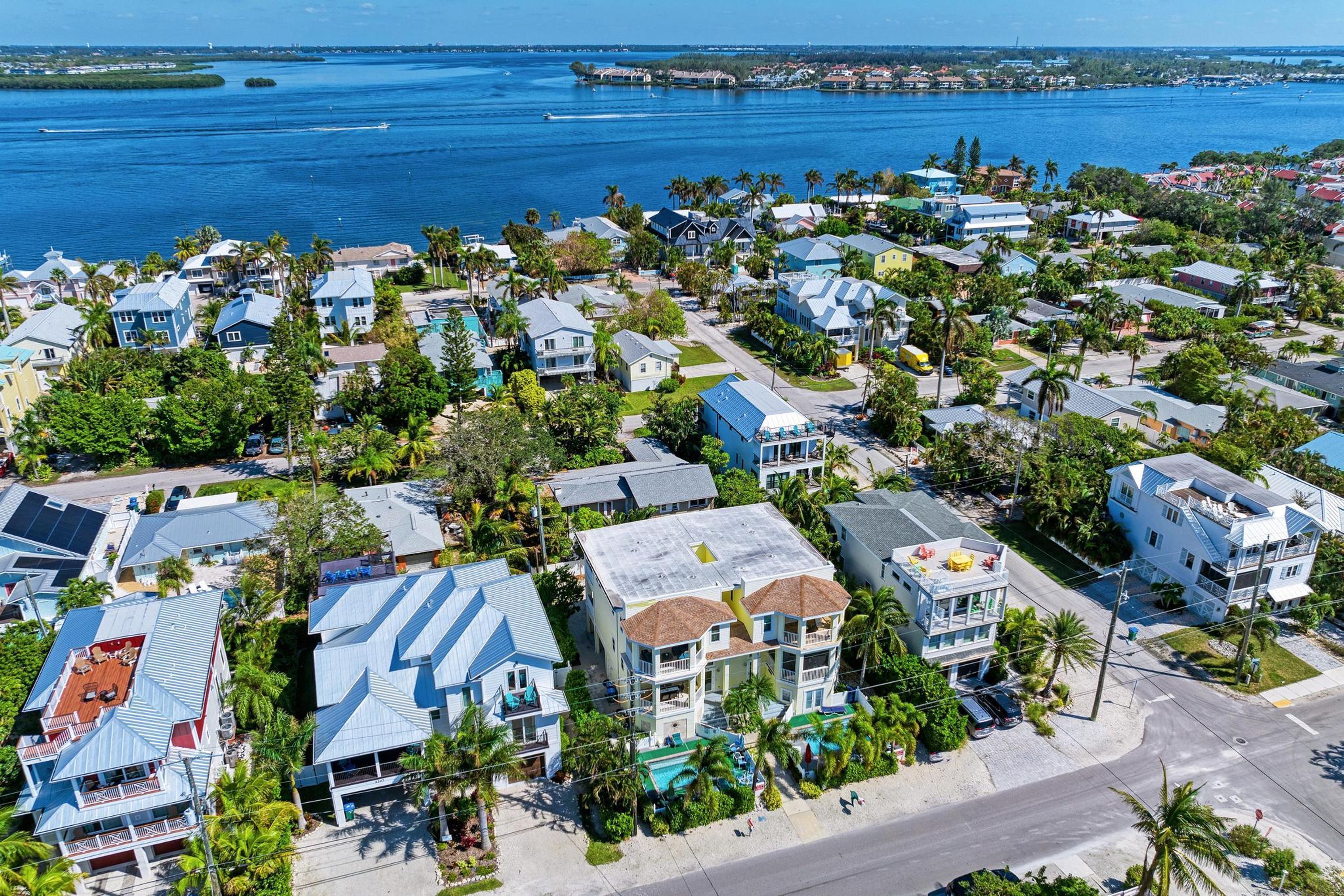 Un área residencial costera con casas, palmeras y vistas al océano.