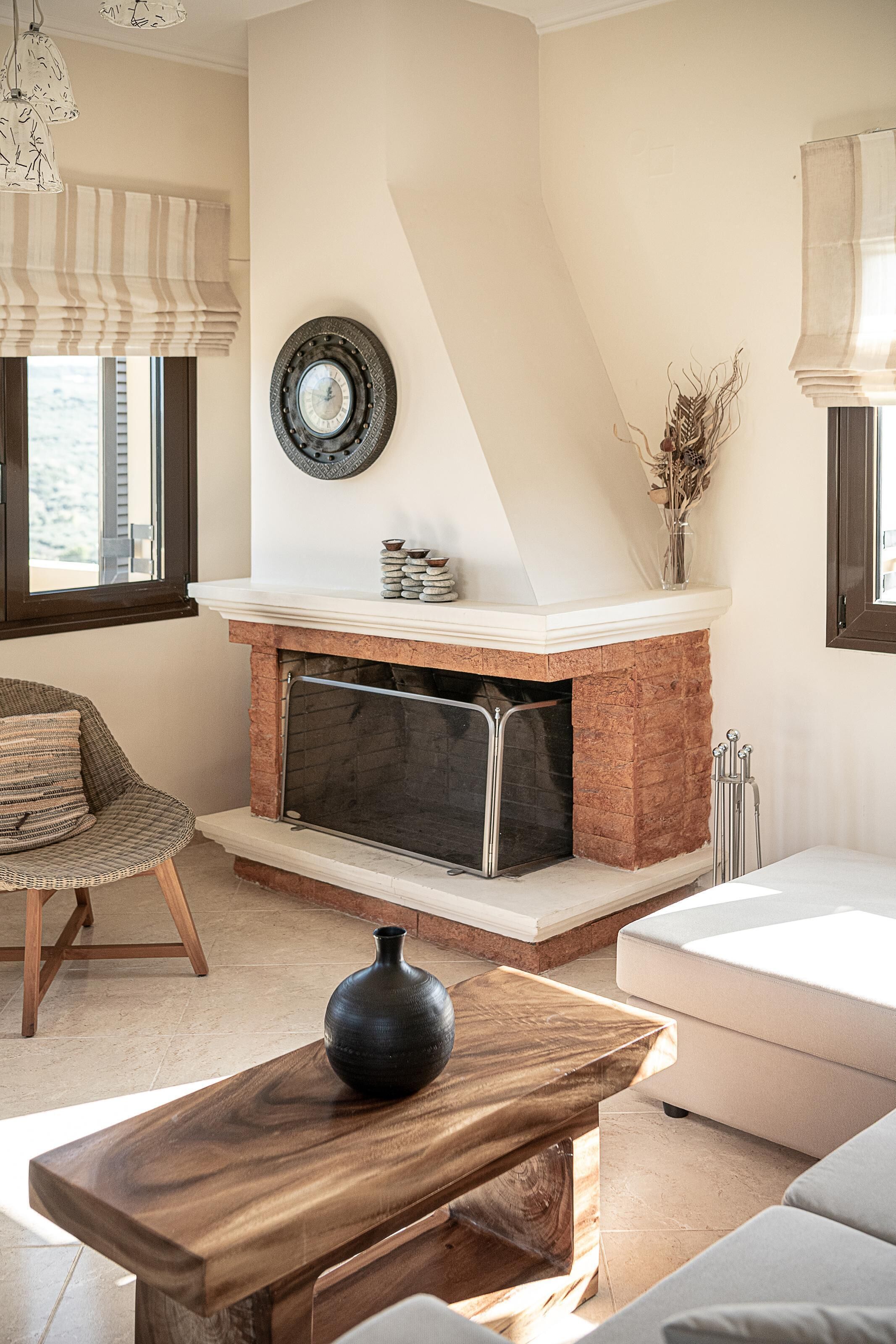 A living room with a fireplace, a sofa, a wooden coffee table, and a chair.