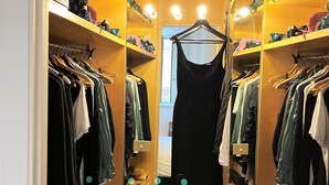 A walk-in closet with multiple shelves and hanging space, featuring a variety of clothing and shoes. - APARTMENT 6 CASTEL SANT'ANGELO RELAIS (Roma)
