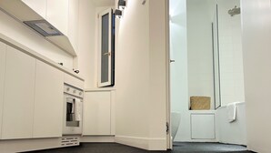 A modern office space with a kitchenette, a large window, and a shower area. - APARTMENT 6 CASTEL SANT'ANGELO RELAIS (Roma)