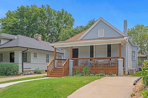 A single-story house with a front porch, a chimney, and a clear sky.