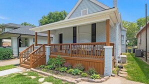 Einbungalow mit Veranda, einer kleinen Terrasse und einem Garten.