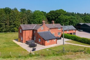 A large brick house with a patio area and a small garden.