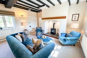 A living room with a fireplace, two sofas, and a chair.