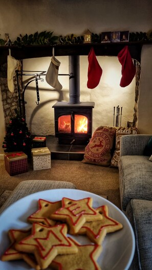 A cozy living room with a fireplace, a Christmas tree, and a plate of star-shaped cookies.