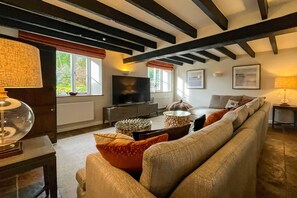 A living room with a sofa, a television, and a fireplace.