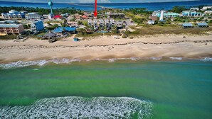 Ein Luftbild einer Küstenstadt mit Gebäuden, einem Strand und einem Leuchtturm.