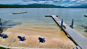 A lakeside beach with a wooden pier, clear water, and a forested mountain backdrop. - Almost Heaven-Lakefront-Shared dock w/Annie's Place-Rent both for a 6-room getaway for large groups! (McCall)