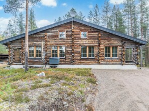 A log cabin with a gravel driveway, surrounded by trees. - Kultatunturi by Interhome (Pelkosenniemi)