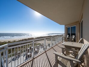 A balcony with a view of the beach, outdoor furniture, and a clear sky. - Luxurious 4 bedroom oceanfront condo in the most prestigious building in OC, (Ocean City)