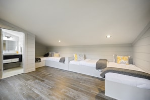 Relax in a serene space with a bench, large mirror, and sleek cabinet.