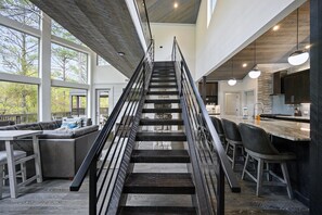 Stunning interior with a central staircase, sleek railing, and chic seating area.