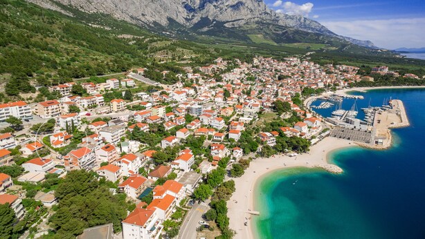 An aerial view of a coastal town with buildings, a beach, and a marina. - 5 Bedroom Villa, Pool, Sea Views, Baska Voda (Baska Voda)