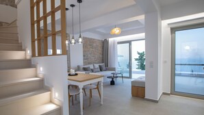 A modern interior with a staircase, dining area, and a balcony with a view.