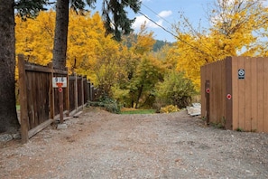 A gravel path leading to a wooden gate with a number sign and a no smoking sign. - Downtown Leavenworth Cottage w/ Hot Tub, Fireplace, BBQ (Leavenworth)