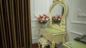A vintage vanity with a mirror, a small stool, and a telephone. - Hoa Dong Aureum Hotel Ha Nam (Phu Van)