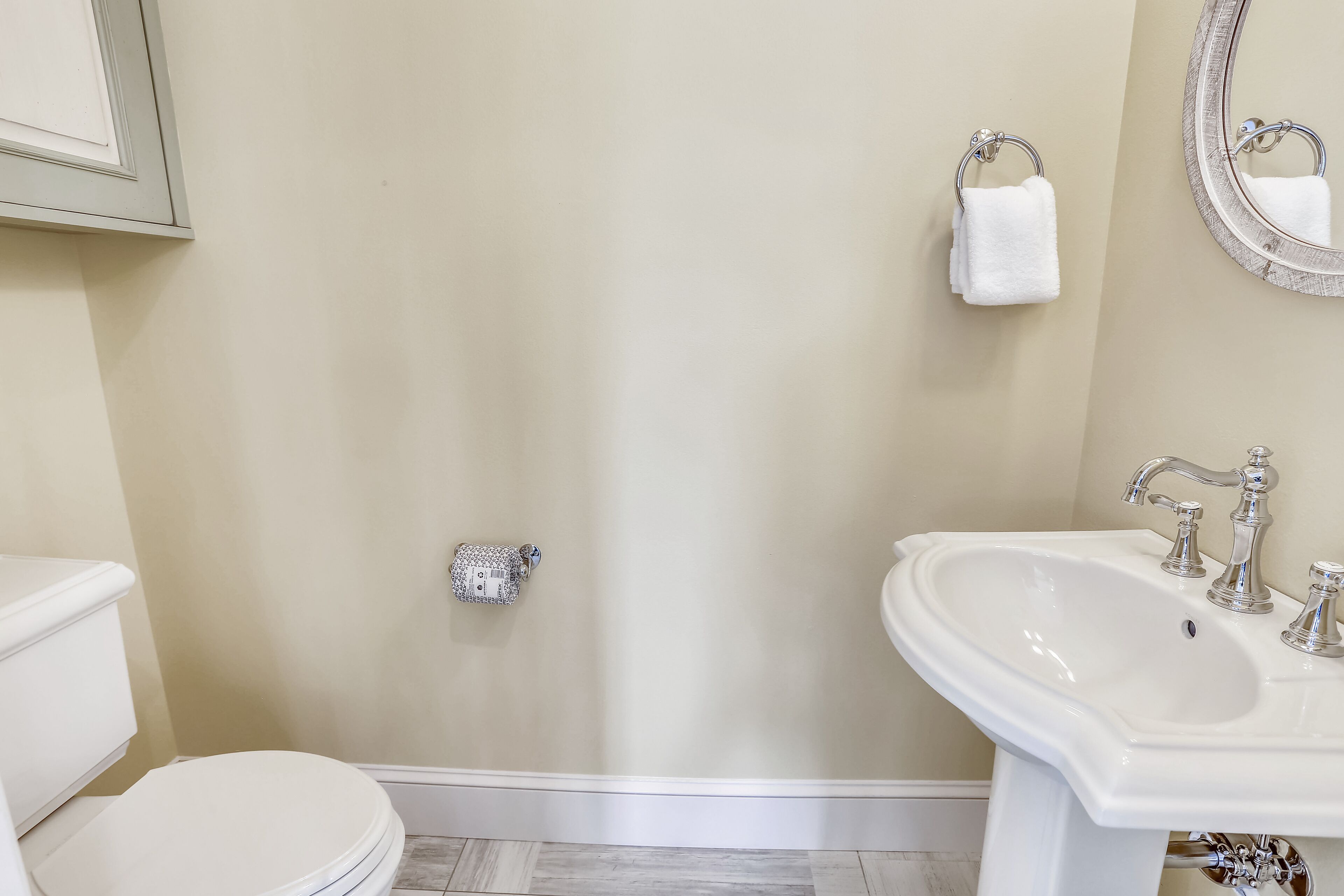 A bathroom with a toilet, sink, and towel rack.